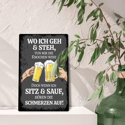 Blechschild "Wo ich geh & steh tun mir die Knochen weh! Doch wenn ich sitz & sauf, hören die schmerzen auf"